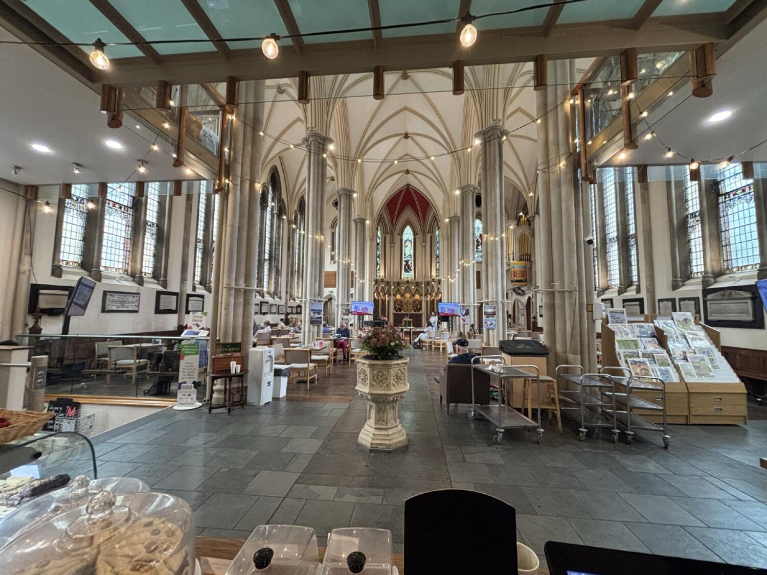 Seating area on left. Central path with pillars. Display shelves on right.