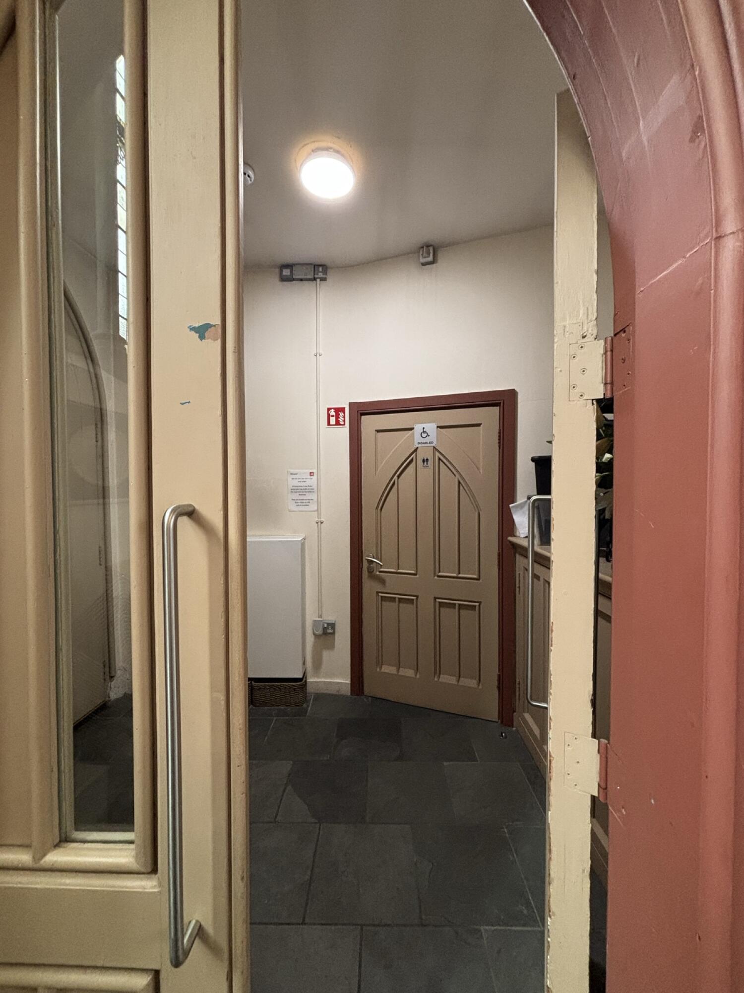 Beige wood-framed glass door. Use handle to open.