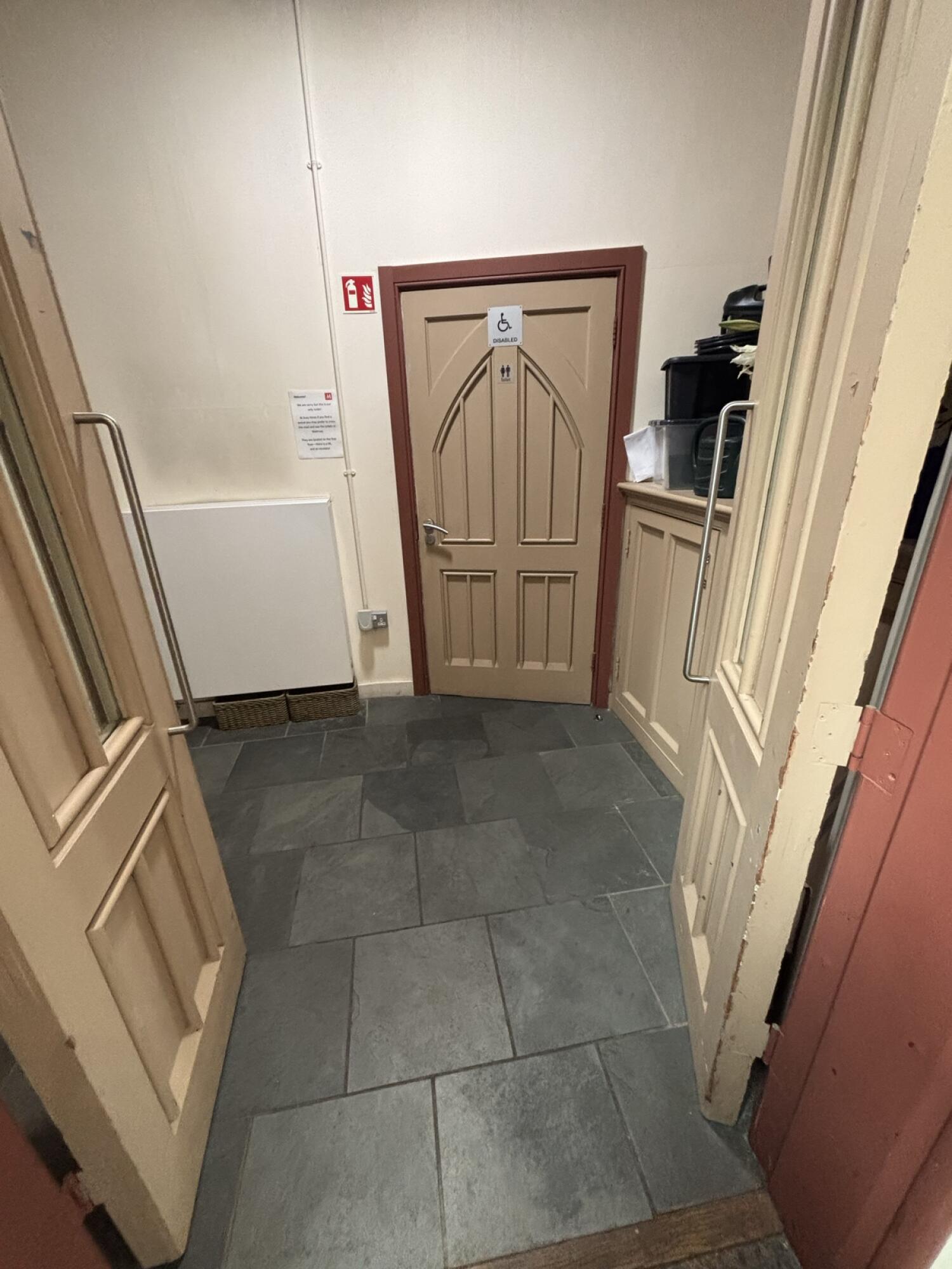 Beige wooden door ahead. Use handle to open.