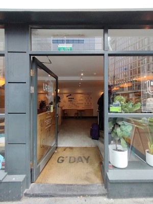Glass door with grey frame. Silver pad on right. Push to open.
