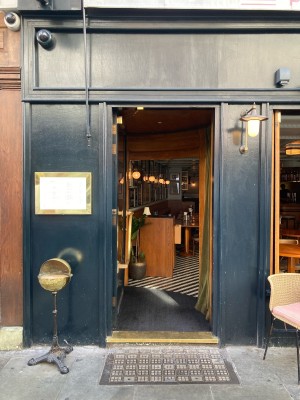 Access via glass door with dark blue frame. Push open via metal handrail in center.