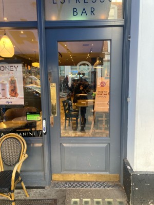 Glass door with grey frame ahead. Push to open from left.