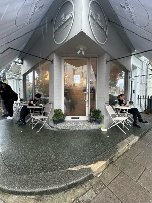 From corner of street facing venue. One step up to outdoor seating along either side of entrance. Door at back after another step.