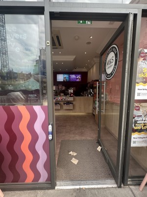 Main entrance. Single glass door with handle on the left. Push.