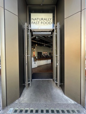 Glass doors with silver doorframe. Silver vertical handles in centre of door, pull to open.