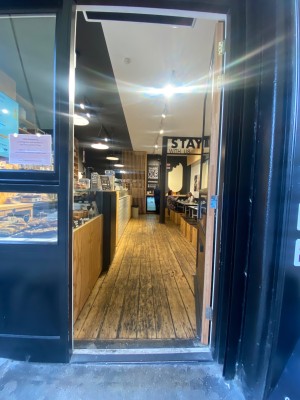 Glass door, with black doorframe. Silver handle on left. Push to open.