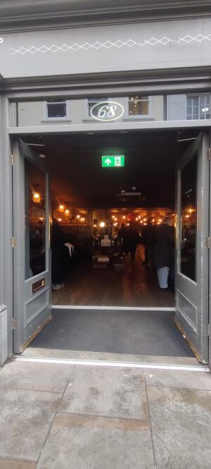 Grey wood framed glass door ahead. Push strip at center.