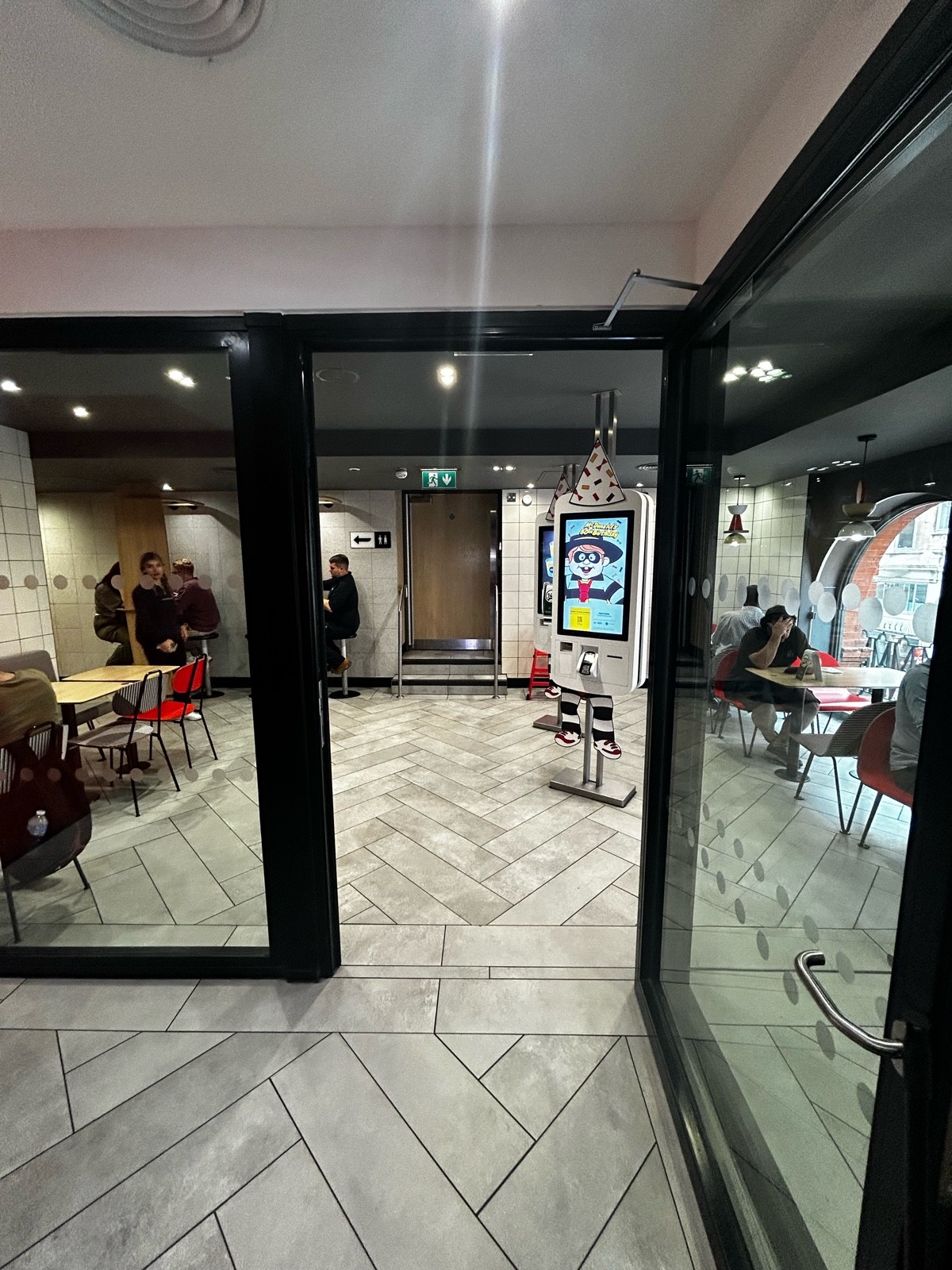 From path, facing left. Preceding glass door with black frames ahead. Silver handle on mid left. Pull to open.