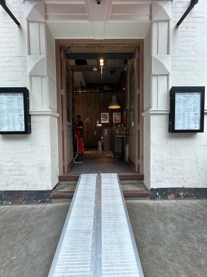 Wooden doors with glass panels. Push black vertical handles in middle to open. 2 steps up to entrance.