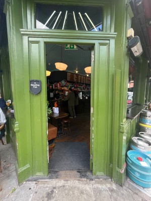 Single glass door in green wooden frame. Push from left to open.