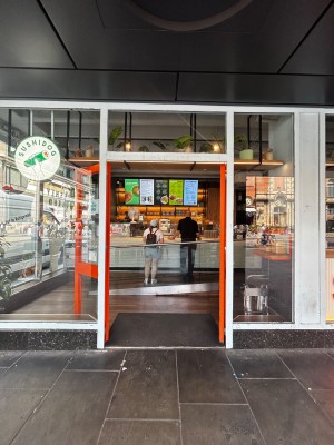 Glass door with orange frames. Silver handles on middle. Push to open.