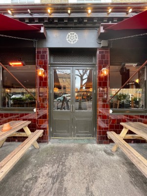 Double glass doors with dark grey frame. Pull sliver handles in center to open.