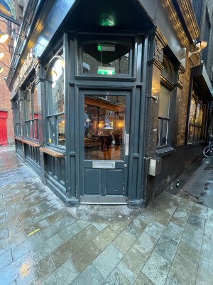 Wood-panelled glass door. No handle. Push silver plate on right to open.