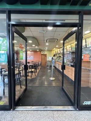 Glass doors ahead with black frame. Push black handles in centre to open.