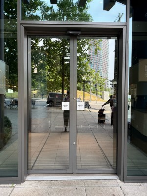 Glass doors ahead. Doors slide open automatically from the centre.