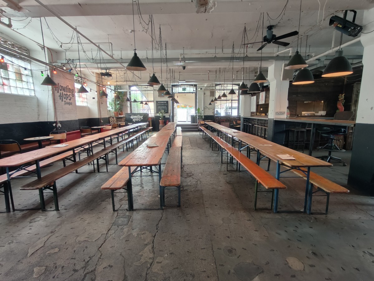 From bar facing right. Rows of tables and benches ahead.