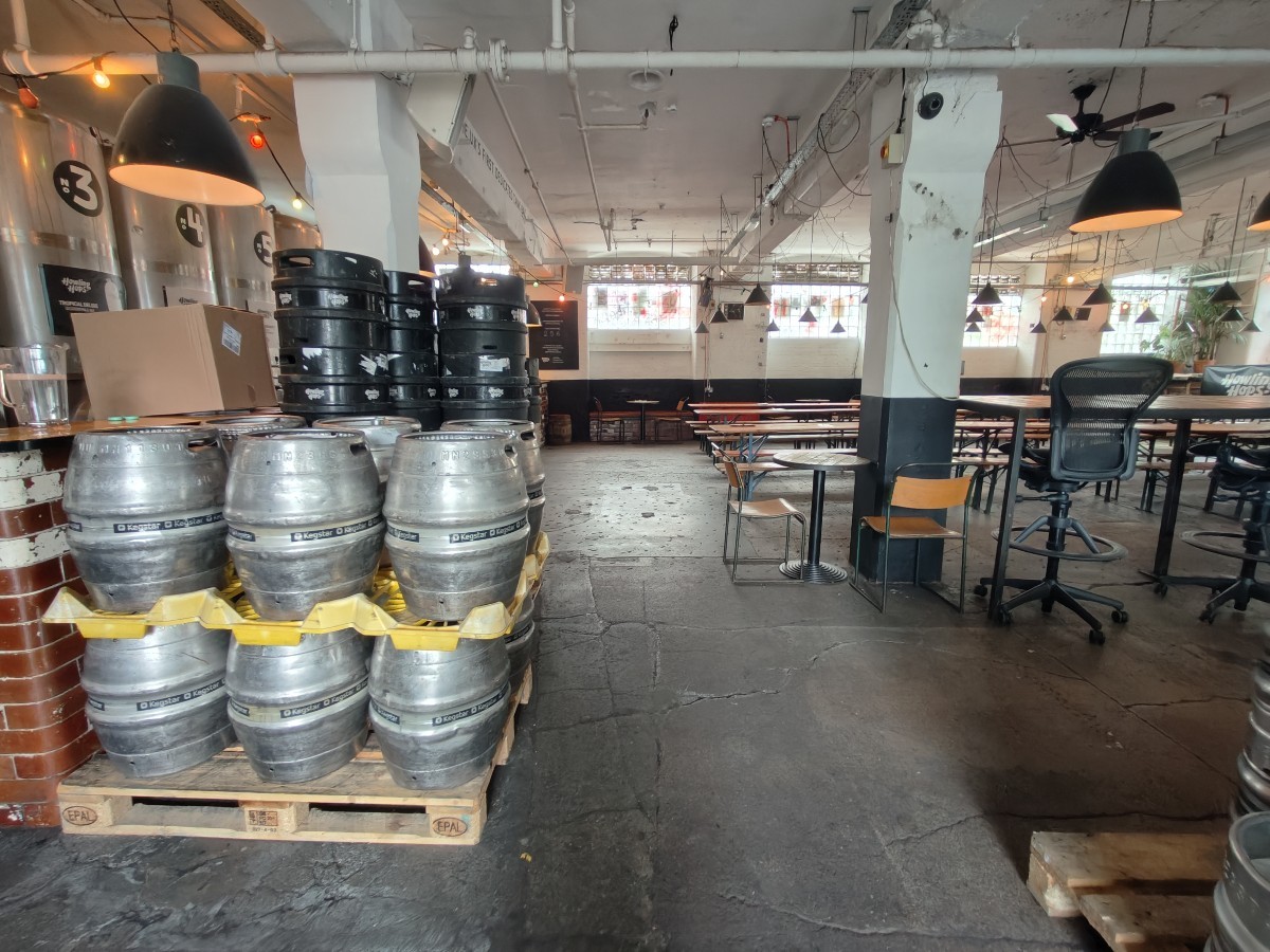 From tables and chairs facing straight. Barrell storage on left. Table and chairs on right.
