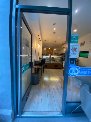 Glass door, with grey doorframe. Handle on right. Push to open.