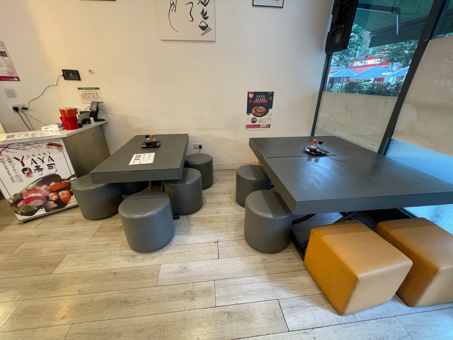 From the entrances, looking right. Seated height tables and stools along back wall, counter at left.
