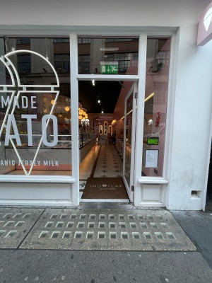 White wood-framed glass door ahead. Glass walls on left and right. No handle. Push on left side to open.