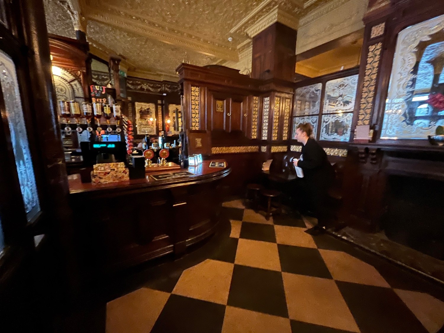 From door facing left. Bar on left wall. Half booth at back right.