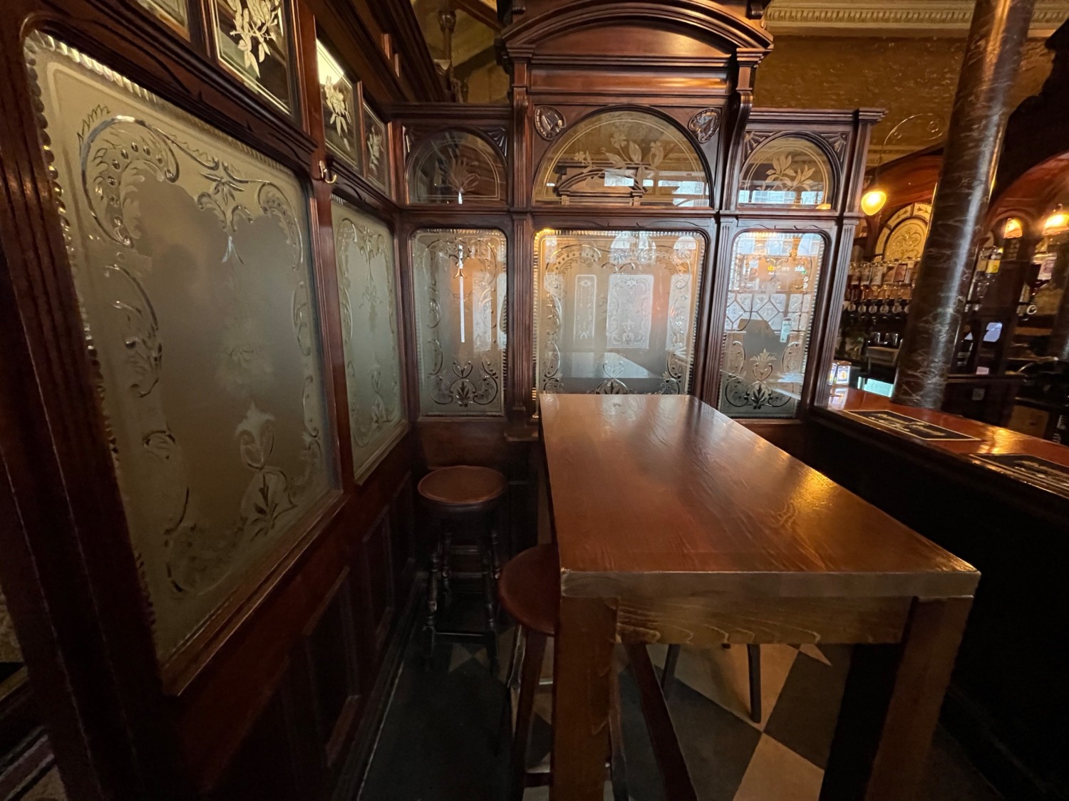 From archway facing left. High table with stools ahead. Bar along right wall.