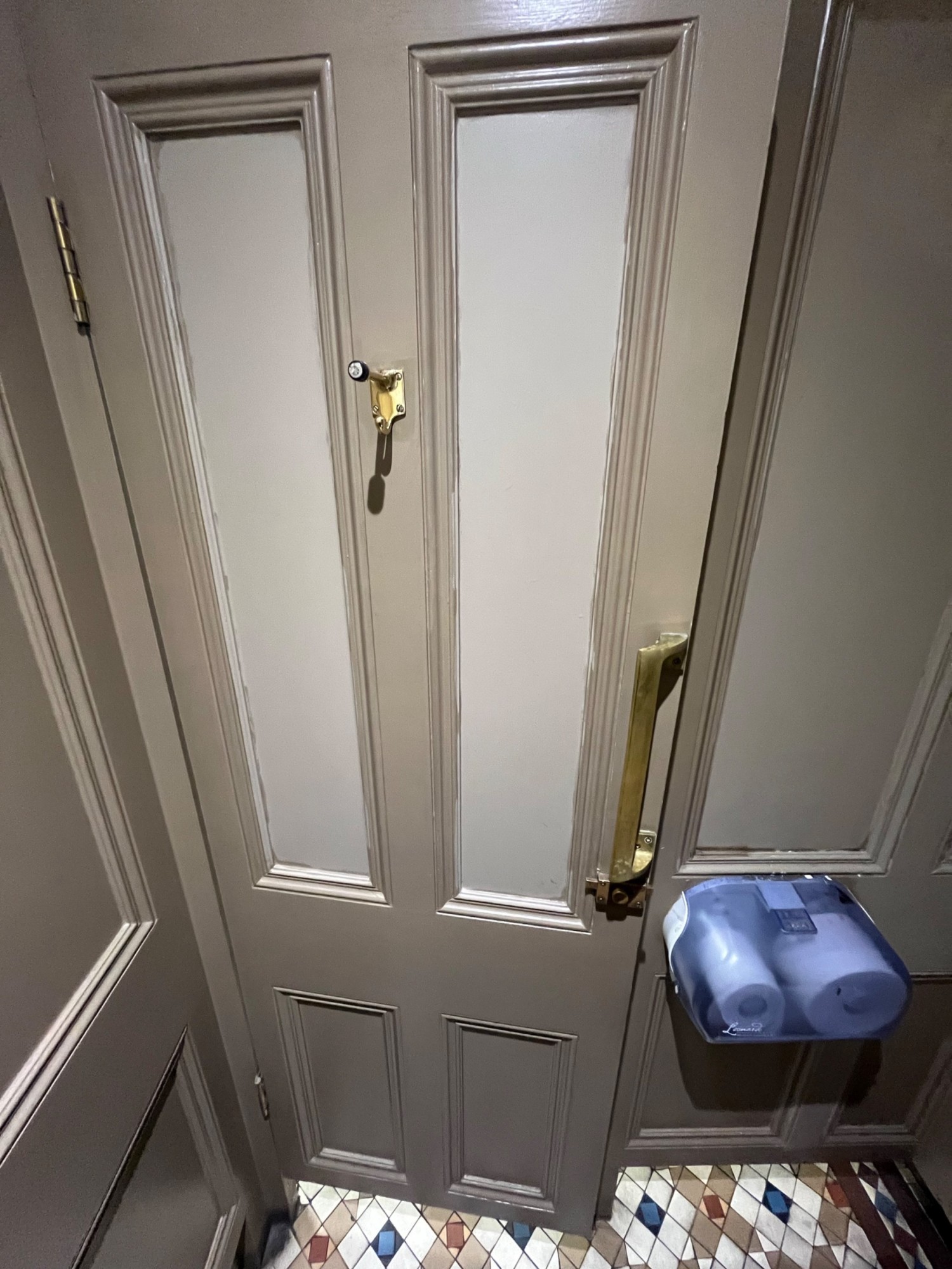 From toilet facing left. Door ahead. Pull open via handle on right. High hanging hook on door.