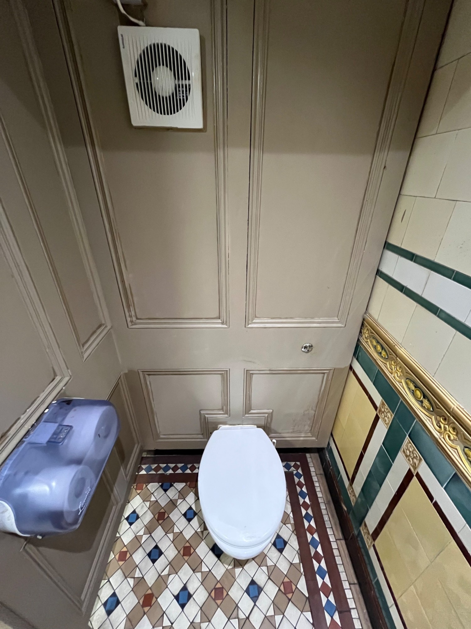 From cubicle door facing straight. Toilet against back wall.