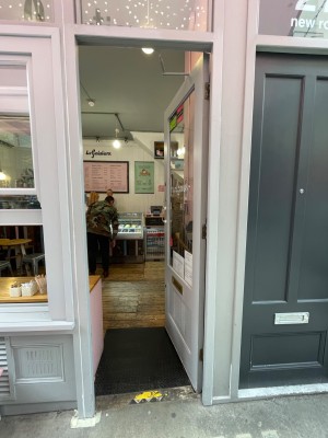 Grey door with glass panel. Handle at left, push to open.