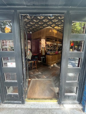 Grey framed glass door ahead. Push open from right side.