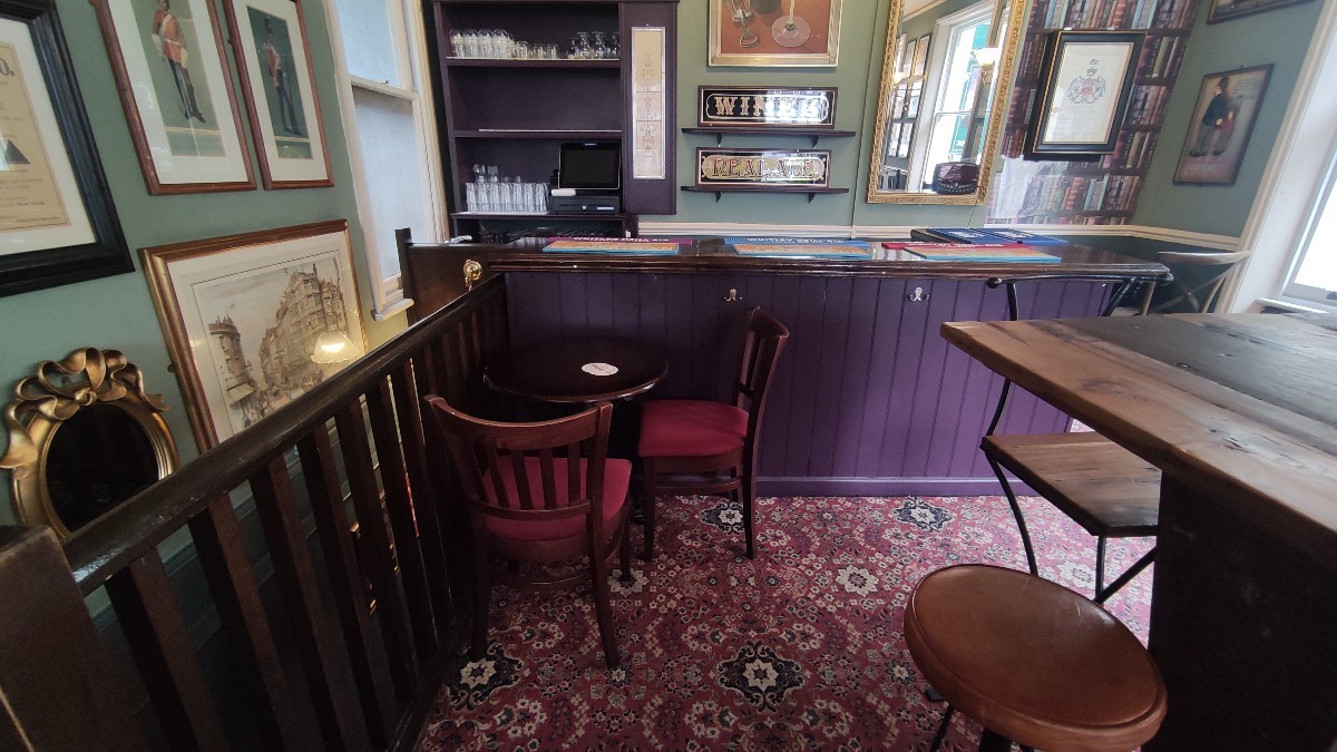 From top of staircase facing left. Path ahead. Table and chairs at the back. Bar area at the back.