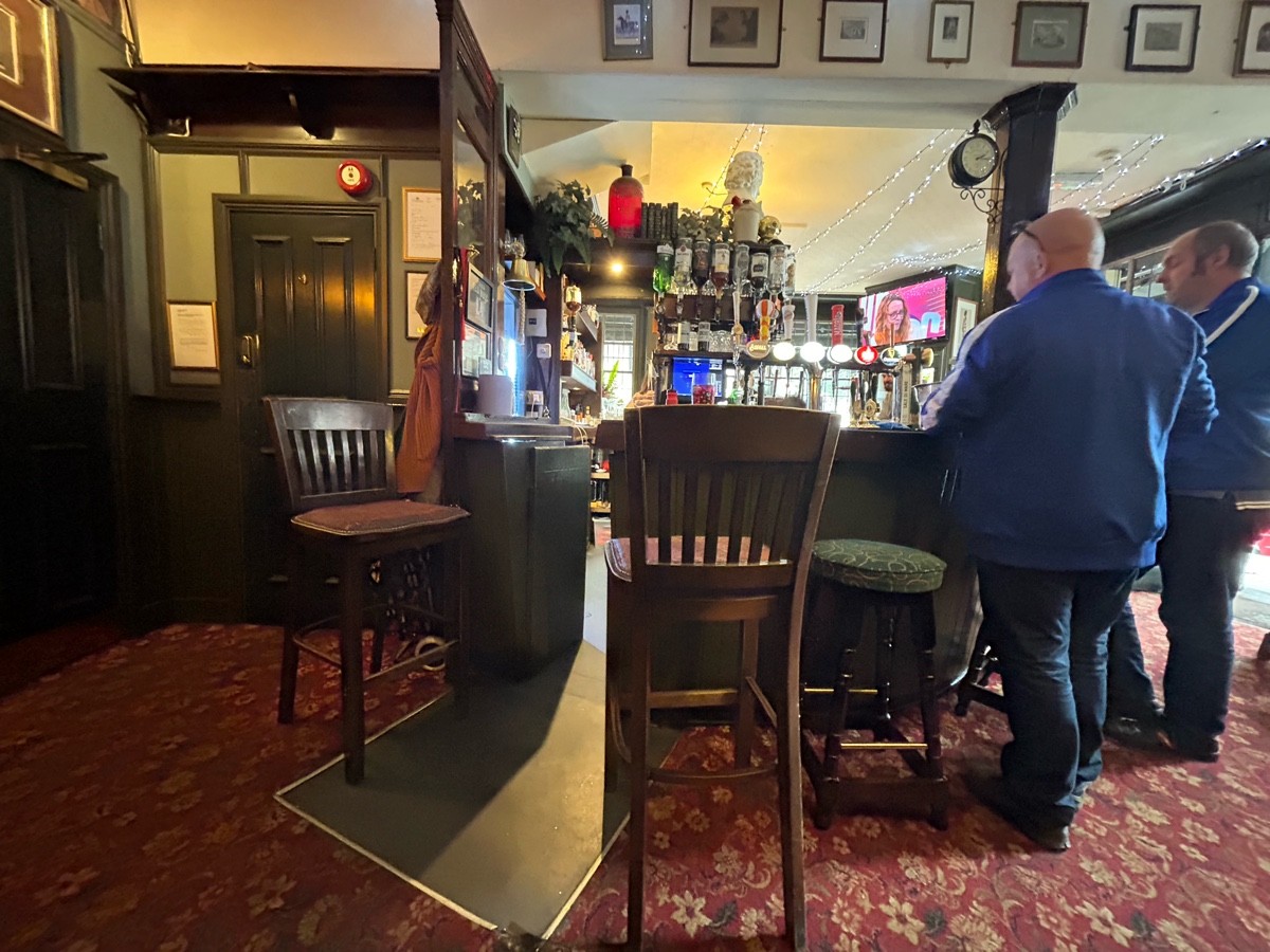 From high table facing right. Bar along back, ends on left. Stools along counter.
