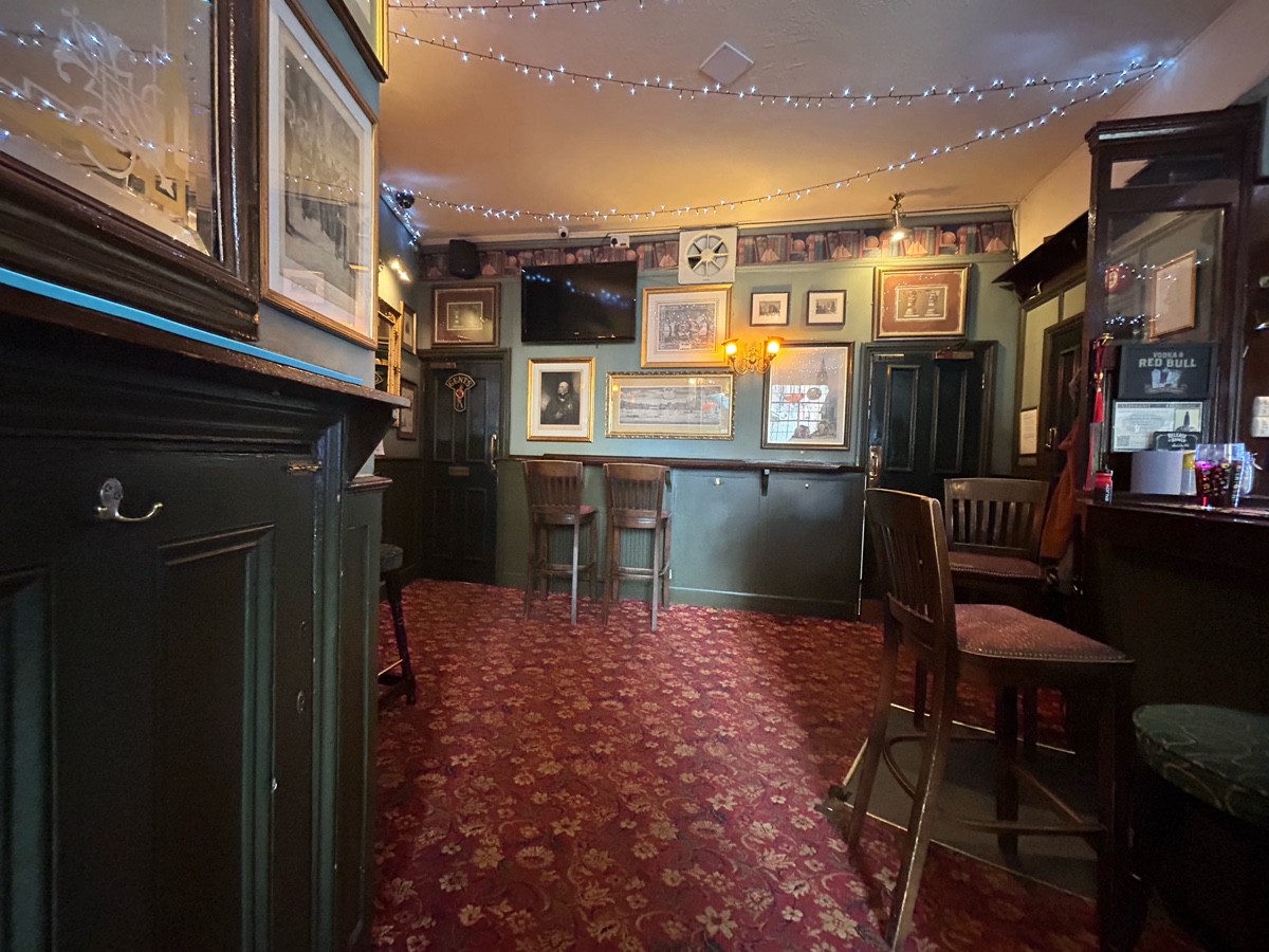 From end of half booth facing right. Bar on right lined with stools. Path ahead leads to high table and stools at back and back left.