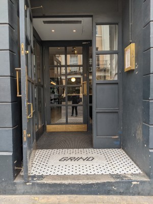 Blue door with glass panels and gold handle. Pull from right to open.