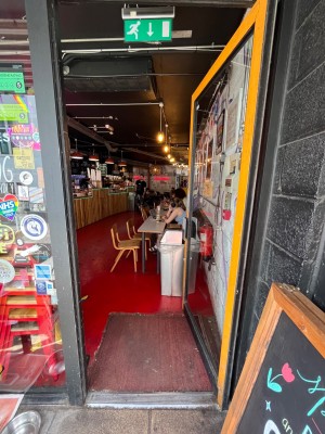 Glass door with yellow frame. Push, silver metal handle on left to open.