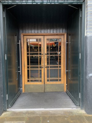 (1) Entrance to centre of venue. First doors push to open via long vertical handles where doors meet. Second doors pull to open by smaller vertical handles where doors meet.