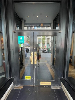Wooden double glass door, handle in the centre. Pull to open.