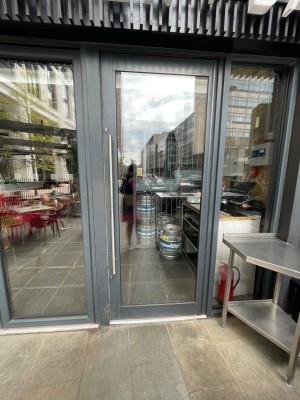 Black glass door with long handle at left. Pull to open.