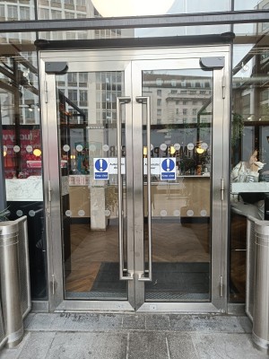 Glass doors with silver, metal frame. Silver, metal handles in middle.