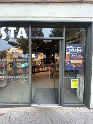 Glass door in metal frame. Push metal handle on left to open.