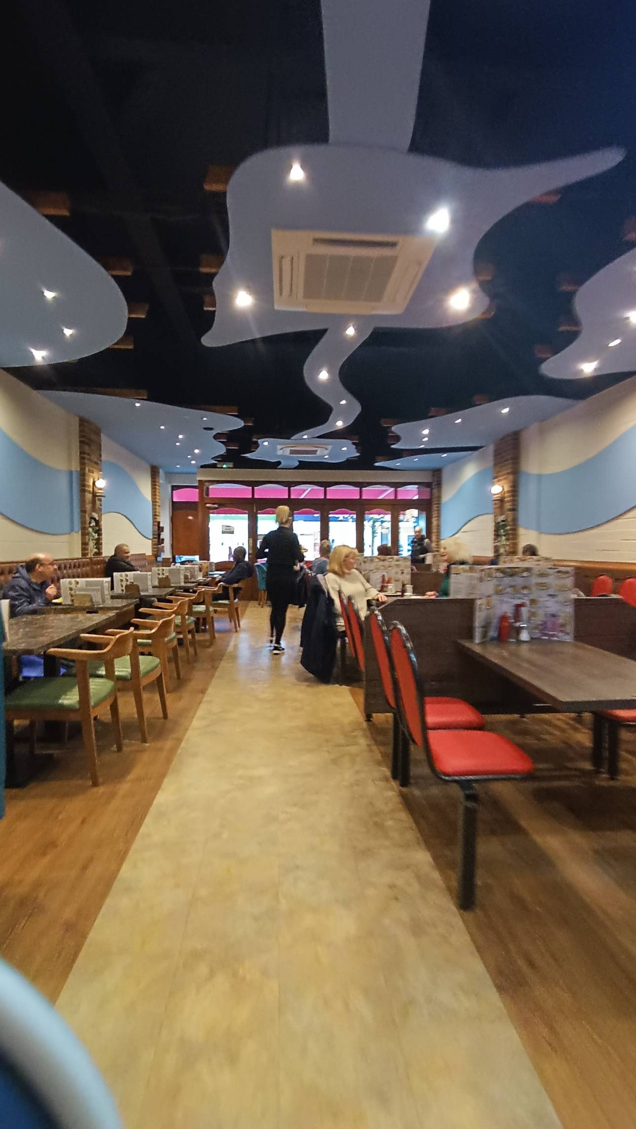 Photo shows booths and half booths with regular pathway through the middle of the café.