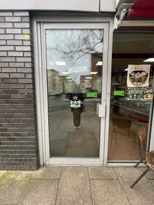 Glass door with white frame. Pull or push handle on right to open.