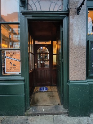 Facing green preceding door. Push from left to open.