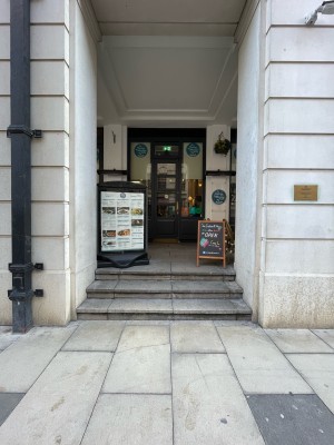 From street facing venue. Three steps up. Signs on left and right at end of steps.