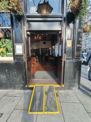 Facing brown framed glass doors ahead. Pull golden metal handles in centre to open.