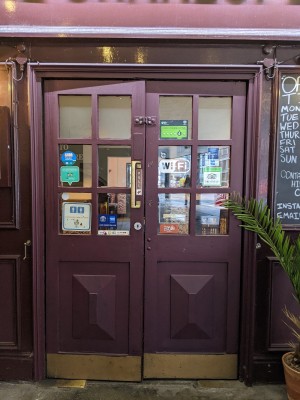 Red and glass-panelled doors. Metal handle on right side of left-hand door, pull to open.