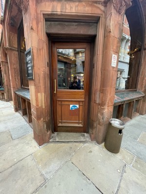 Wood-panelled glass door ahead. Push handle from left to open.