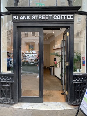 Glass doors with black frames. Push from black handle in centre to open.