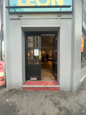 Glass doors with black frame ahead. Push from centre to open.