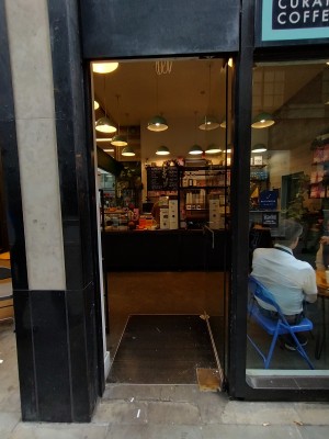 Glass door with silver panel in middle. Push from left to open.